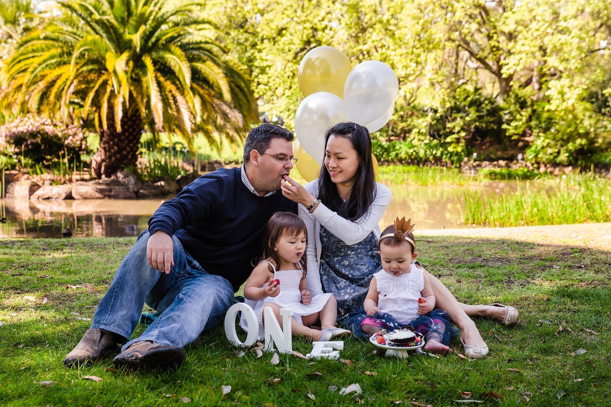 family of four sitting on picnic blanket in queen victoria gardens family photography session