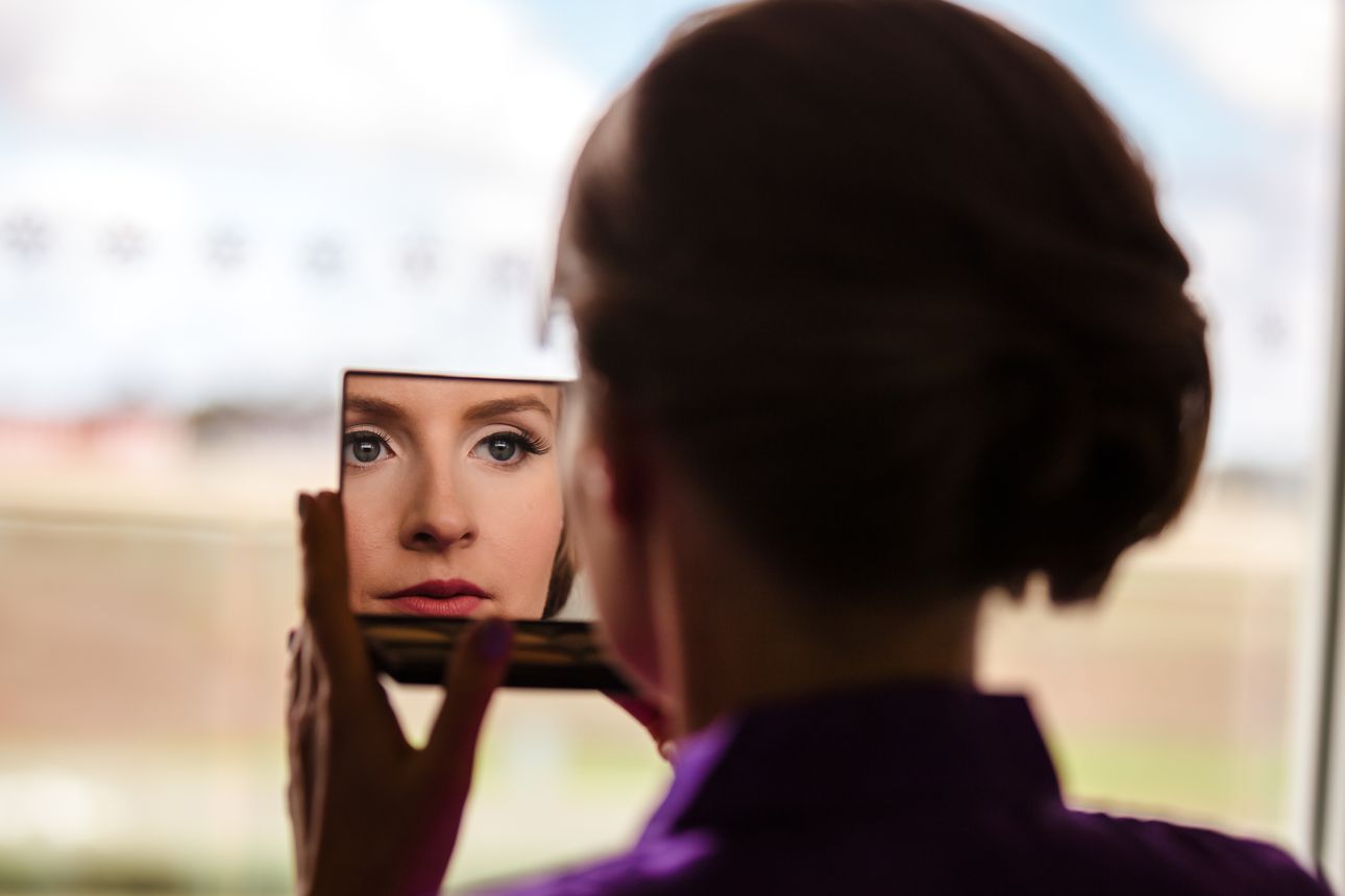 bride looking in the mirror after her make up is complete