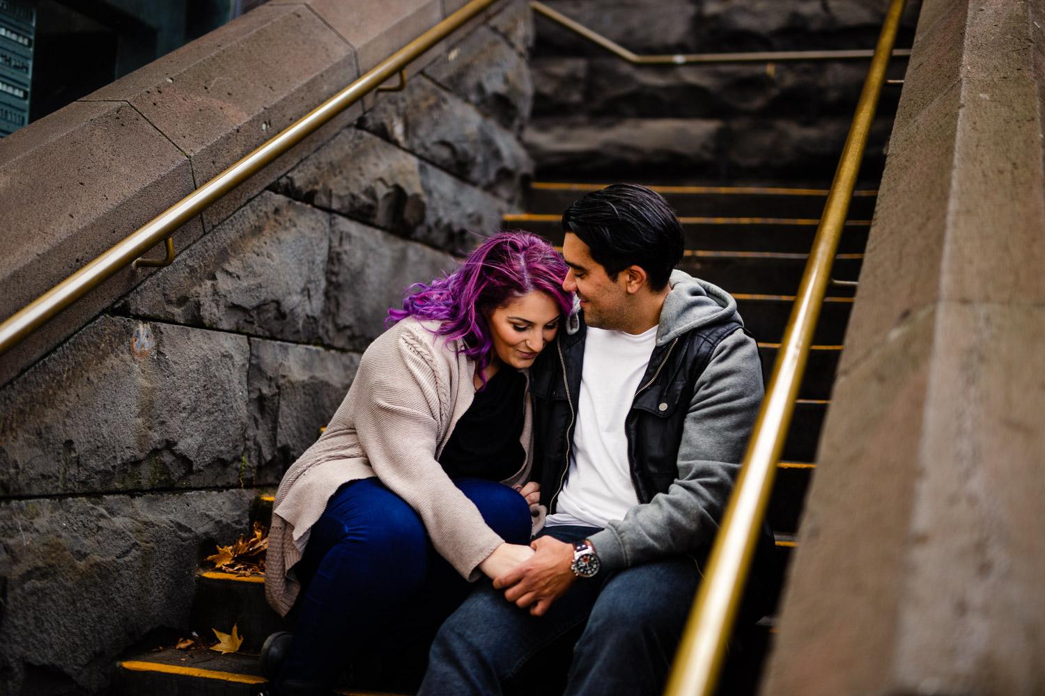 Melbourne couple on sitting on a stone stair case by the yarra river during couples session 