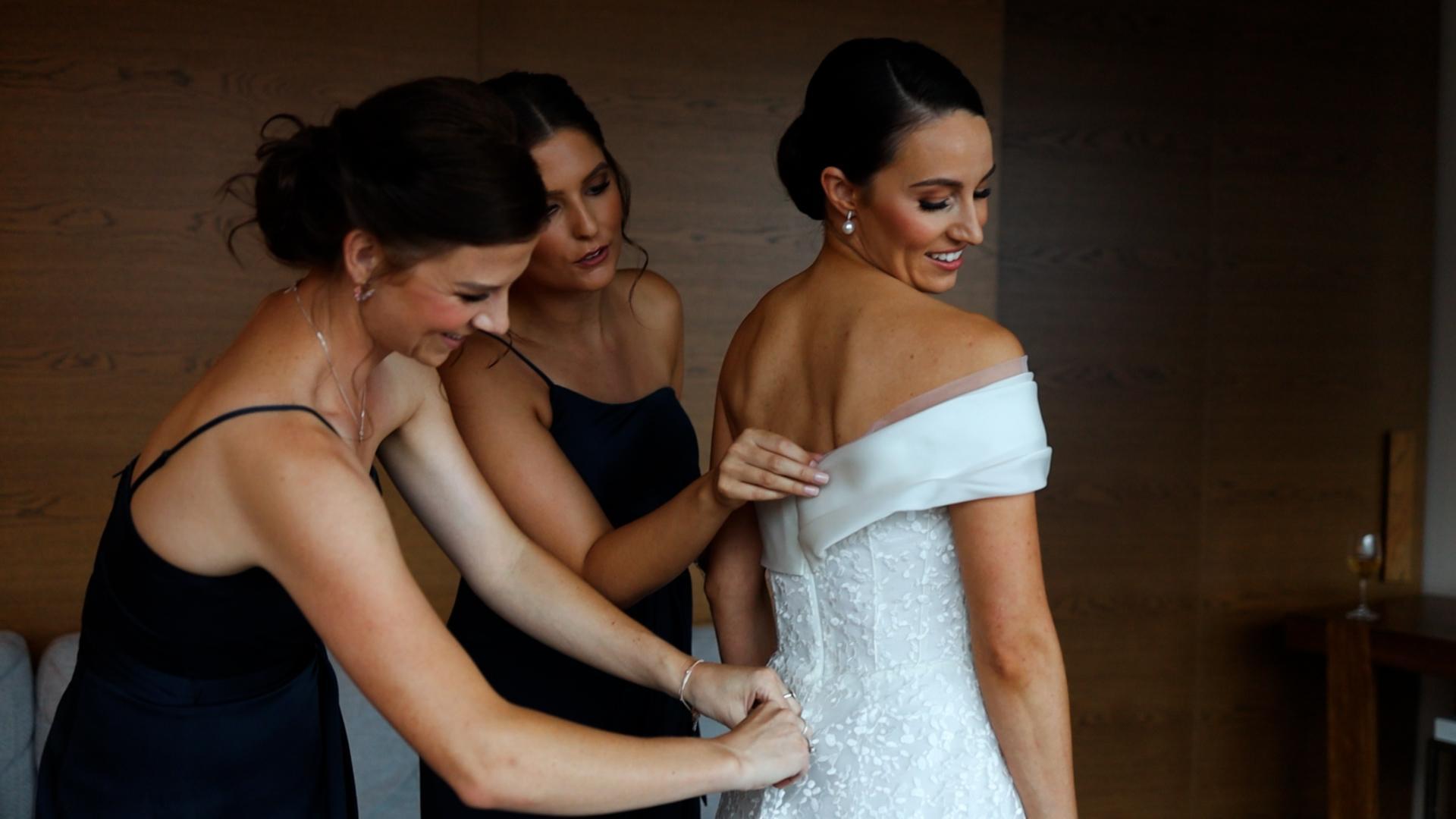 bridemaids helping bride getting ready for her Half Acre Wedding Video