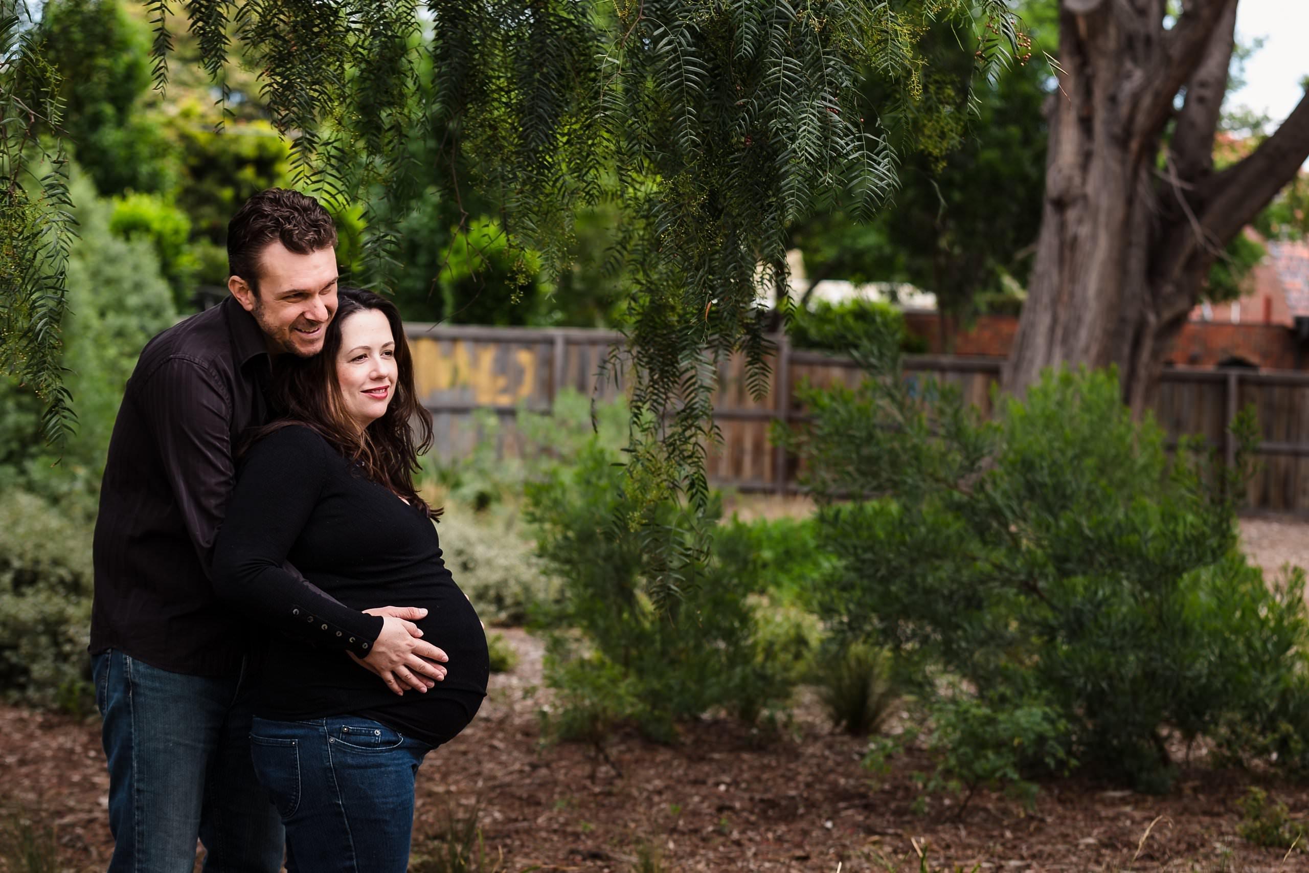 local brighton maternity photographer captures candid moment between expecting couple in park