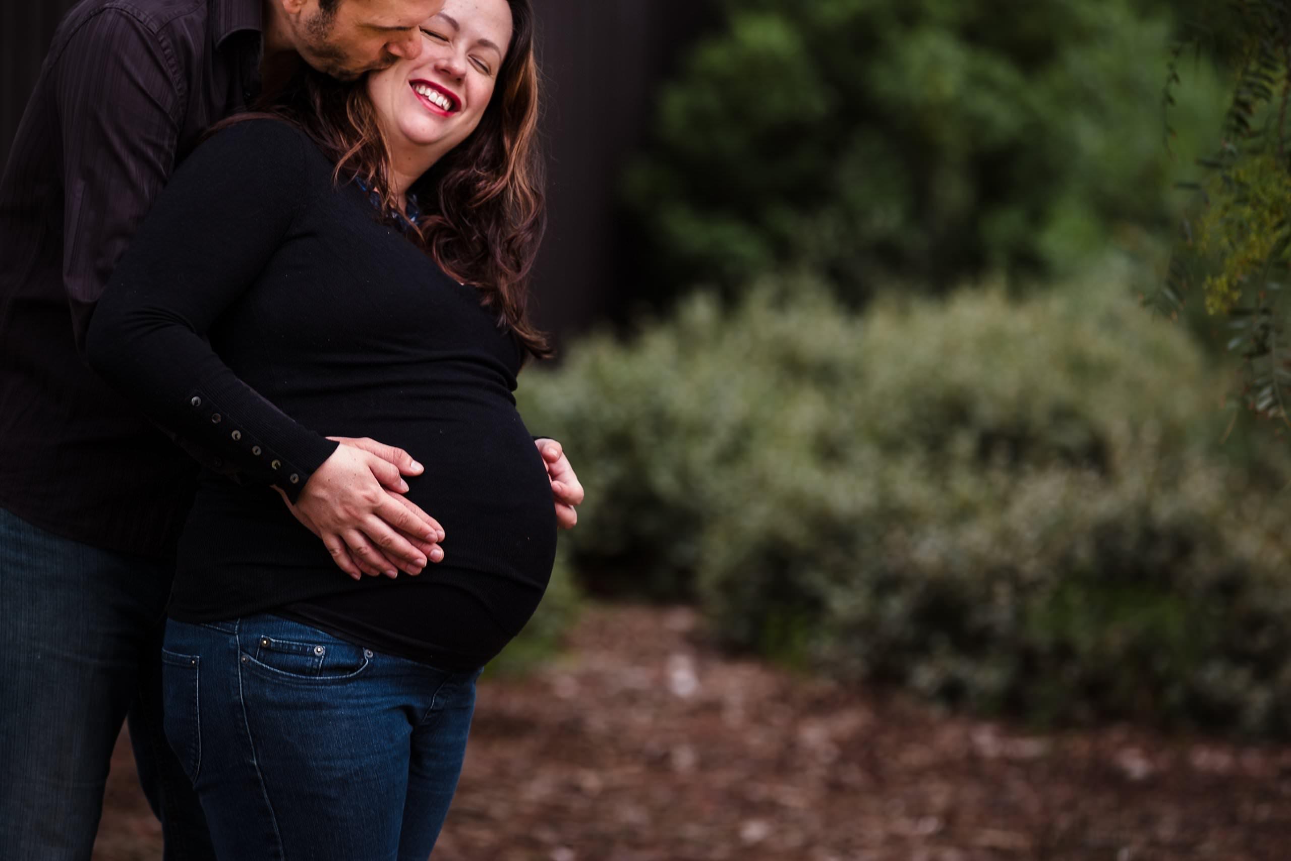 expecting parents holding pregnant belly during brighton maternity photography session
