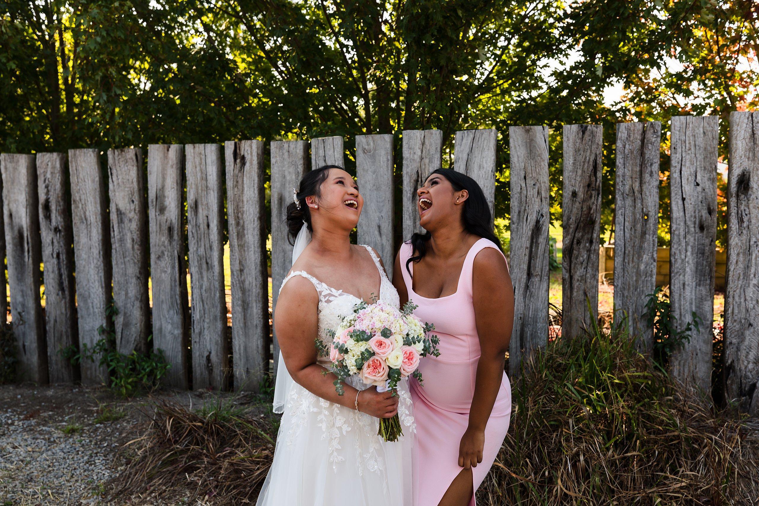 bride with her best friend in a pink dress laughing at killara estate wedding
