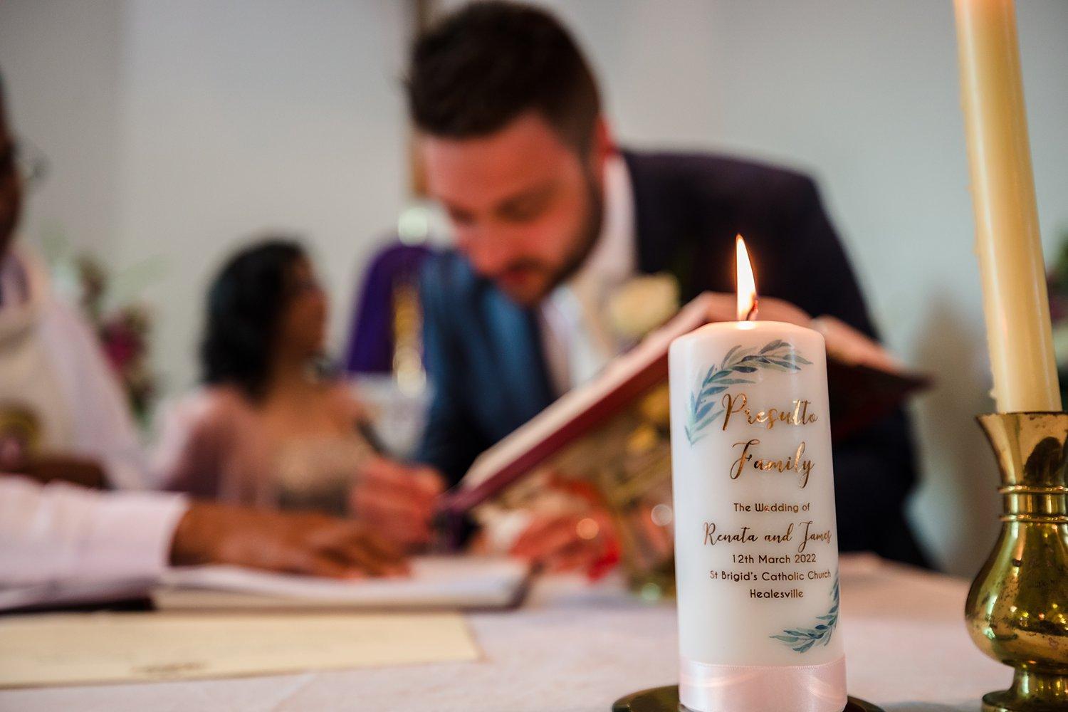 lit candle with the newly weds names and wedding dateon it