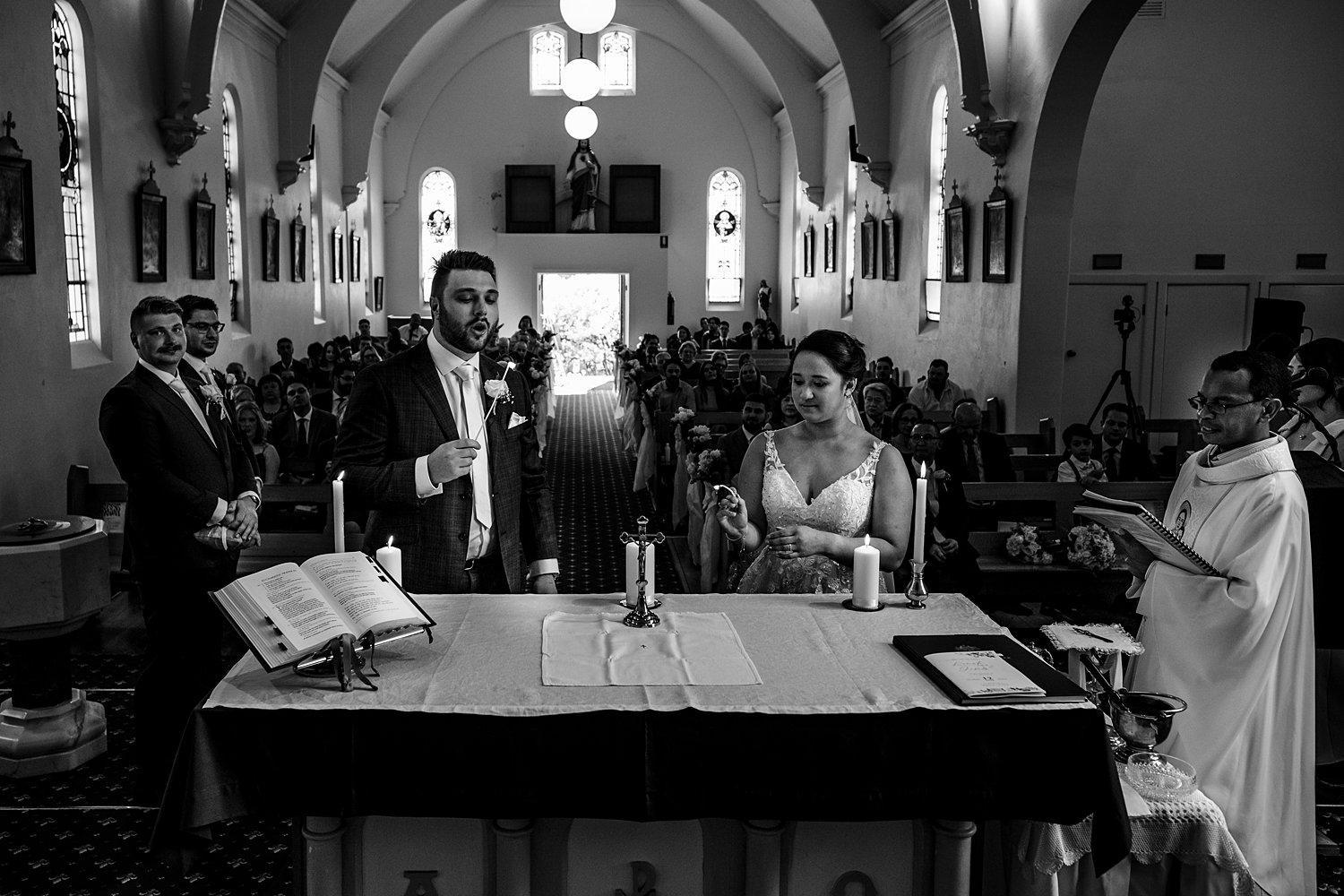 bride and groom light candles during their church ceremony