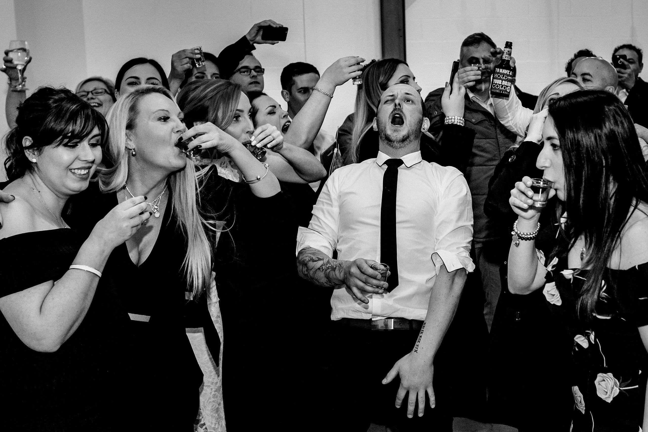 two ton max wedding guests doing shots together