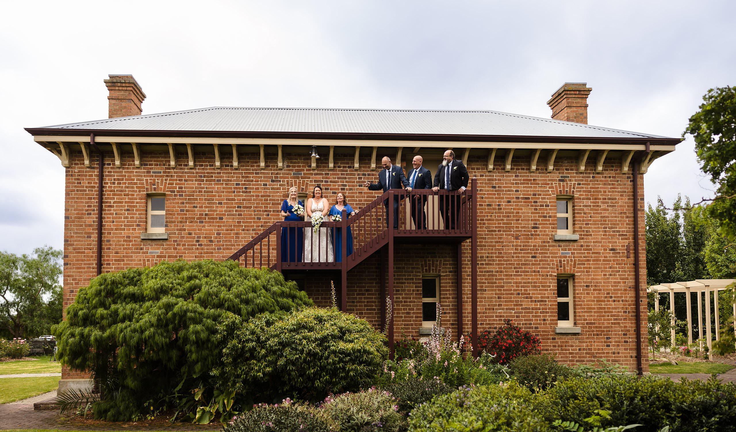 the wedding party on the stairs of the original old cheese factory wedding building
