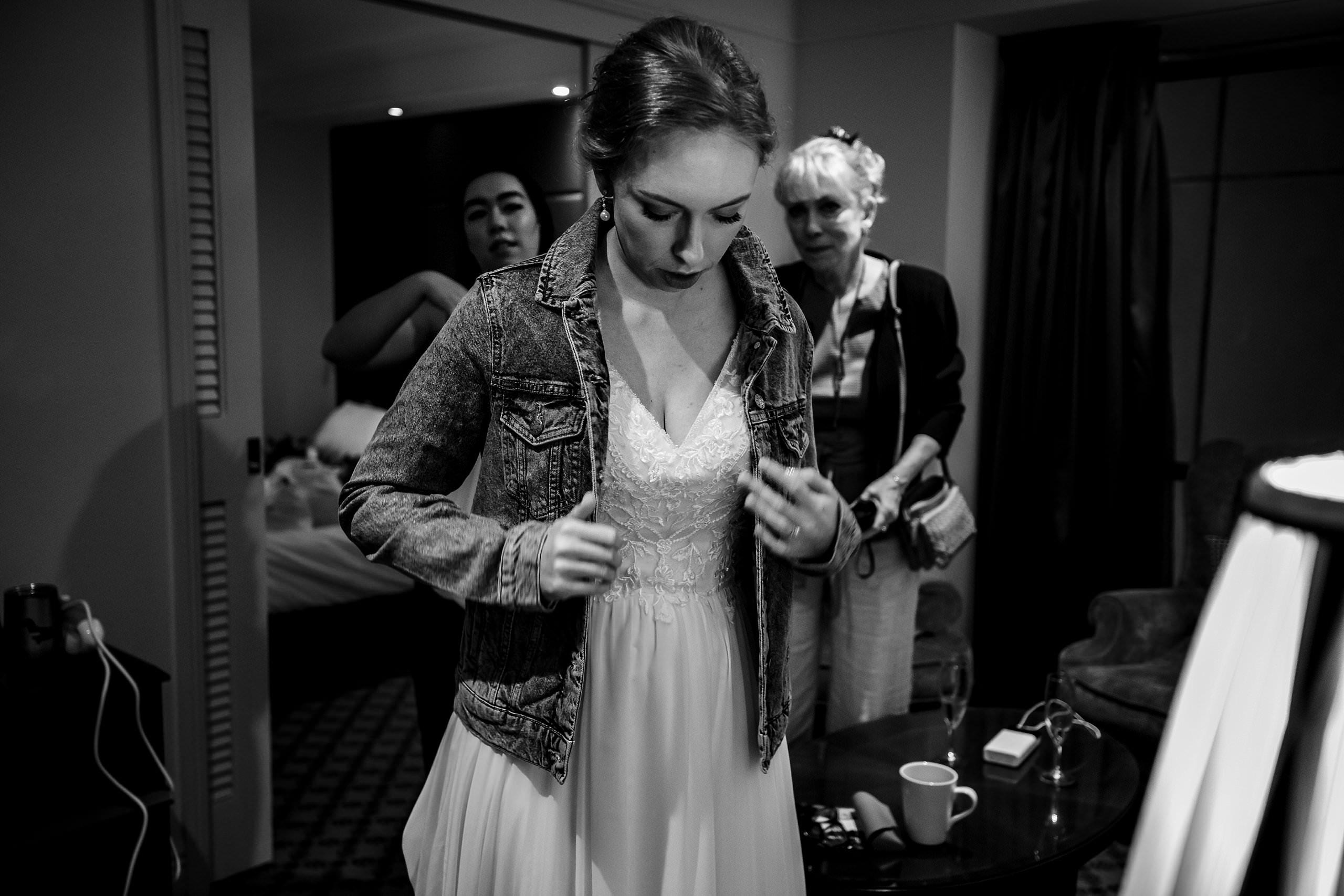 bride putting on a denim jacket
