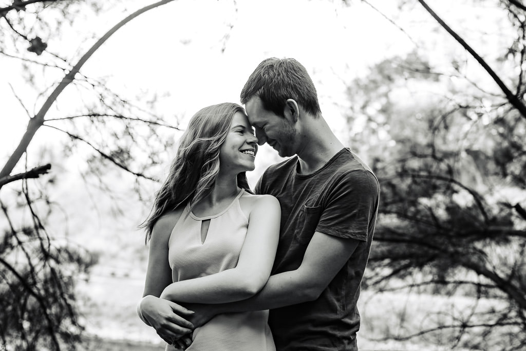 couple holding each other with heads touching during engagement portrait session